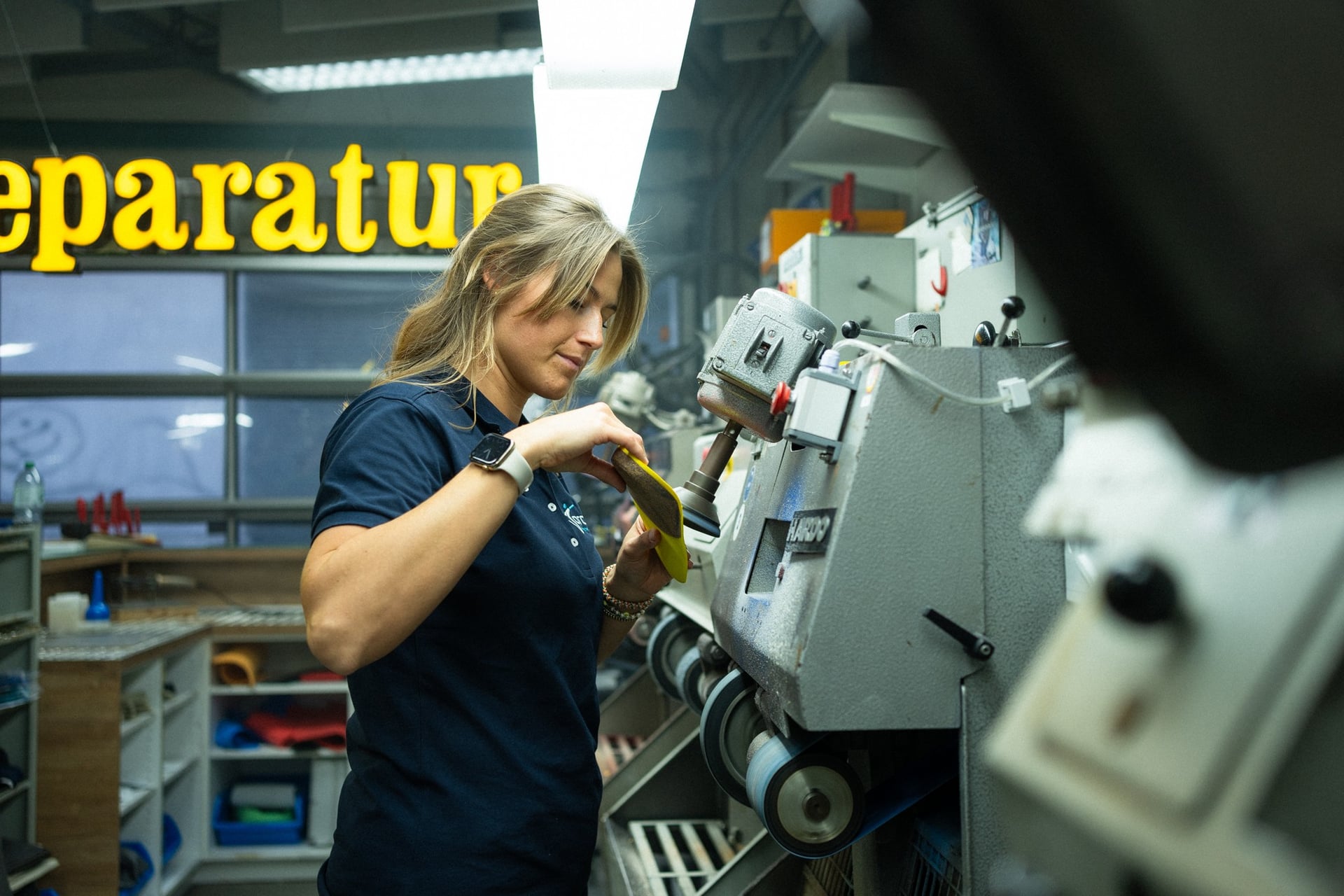 Mitarbeiterin der Jordan Orthopädieschuhtechnik bedient Maschine in der Schuhwerkstatt